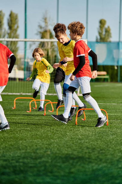 Grupa małych dzieci energicznie gra w piłkę nożną na trawiastym polu. Biegają, kopią piłkę i śmieją się podczas przyjacielskiego meczu.. - Zdjęcie, obraz
