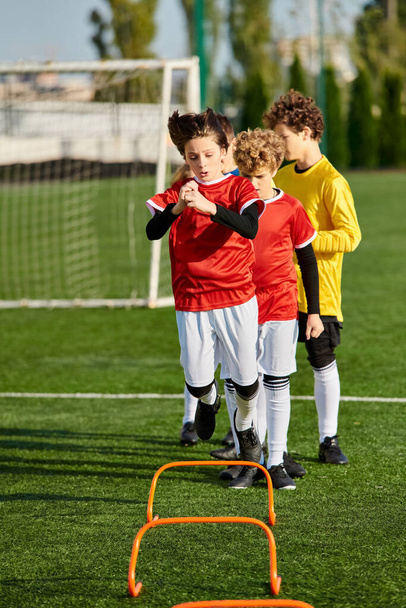 Un groupe diversifié de jeunes garçons se tiennent énergiquement au sommet d'un terrain de soccer dynamique, mettant en valeur leur travail d'équipe et leur camaraderie alors qu'ils se préparent à jouer un match amical animé. - Photo, image