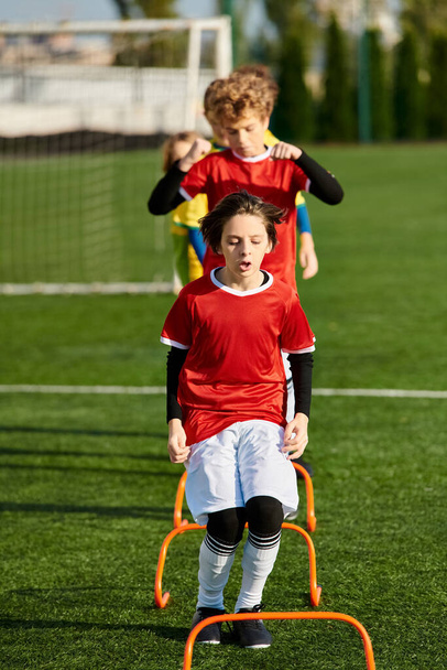 Małe dzieci energicznie grać w piłkę nożną, bieganie, kopanie i podawanie piłki z entuzjazmem i pracy zespołowej. - Zdjęcie, obraz