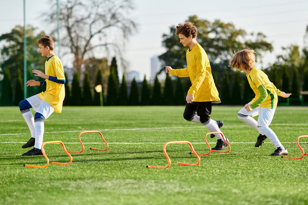 A fiatal gyerekek élénk csoportja örömmel vesz részt egy élénk focimeccsen, futásban, rúgásban és passzolásban a füves pályán. Arcuk izgatottságot és elszántságot mutat, miközben barátságos, mégis versengő szellemben versenyeznek.. - Fotó, kép
