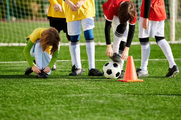Різноманітна група маленьких дітей, наповнена хвилюванням і очікуванням, стоїть навколо футбольного м'яча, спілкується і сміється, коли вони планують свою наступну гру. - Фото, зображення