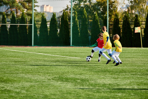 Żywa grupa małych dzieci gra w piłkę nożną, biegając i kopiąc piłkę przez boisko z promieniowaniem uśmiechów i ducha rywalizacji. - Zdjęcie, obraz