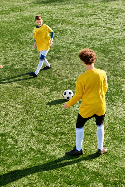 Энергичная группа молодых людей, участвующих в соревновательной игре в футбол на ярком поле. Они бегут, проходят мимо и бросают мяч с энергией и энтузиазмом. - Фото, изображение