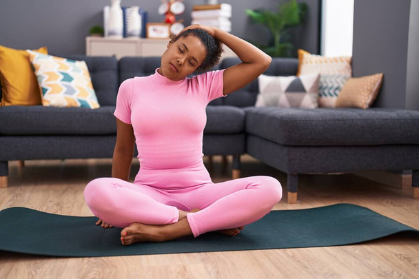 African american woman smiling confident stretching head at home - Photo, Image