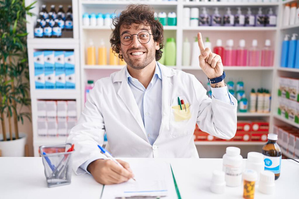 Латиноамериканец, работающий в аптеке, указывает пальцем на успешную идею. Взволнован и счастлив. номер один.  - Фото, изображение