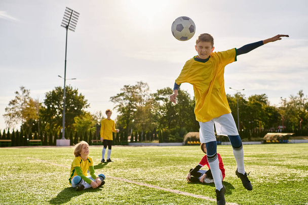 Bir grup genç adam enerjik bir şekilde yeşil bir alanda futbol oynuyor, topa vuruyor, koşuyor ve azimle tezahürat yapıyor.. - Fotoğraf, Görsel