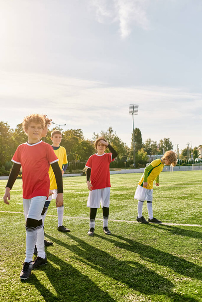 Joukko innostuneita nuoria poikia ylpeänä seisovat jalkapallokentän päällä, osoittaen luottamusta ja päättäväisyyttä, kun he unelmoivat tulevista voitoista ja menestyksestä urheilussa.. - Valokuva, kuva