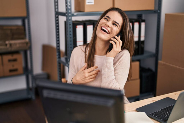 Fiatal gyönyörű spanyol nő e-kereskedelmi üzletember beszél okostelefonon az irodában - Fotó, kép