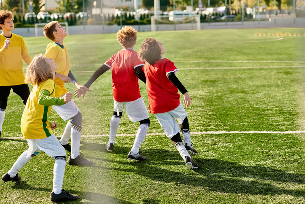 Группа маленьких детей радостно играет в футбол на травянистом поле. Они бегут, пинают мяч, болеют друг за друга, демонстрируют командную работу и спортивное мастерство.. - Фото, изображение