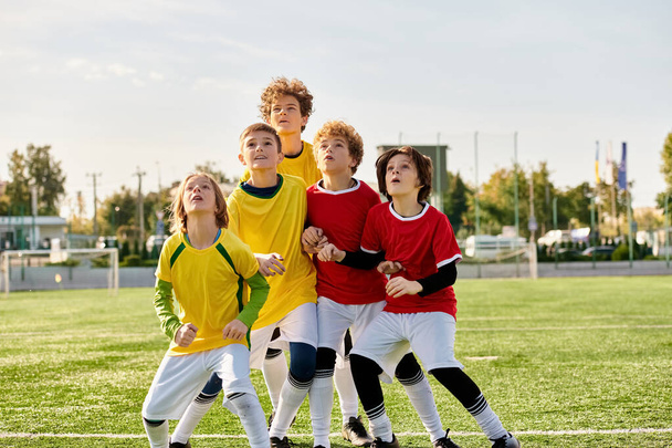 Группа энергичных молодых парней торжествует на ярком зеленом футбольном поле, их лица сияют от волнения и гордости после сложного матча. - Фото, изображение