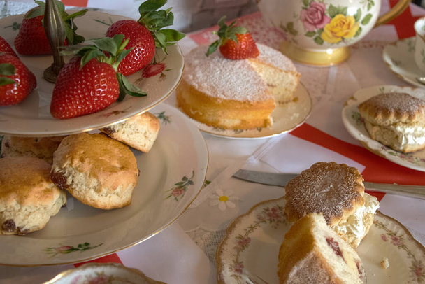 Celebration St Georges day  afternoon tea  vintage  traditional scones strawberries and  cream  victoria sponge cake   england  flag  bunting  - Photo, Image