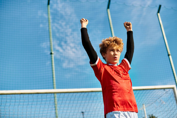 Mladý chlapec sebevědomě stojí na tenisovém kurtu a drží tenisovou raketu. Zdá se, že je soustředěný a připravený hrát hru.. - Fotografie, Obrázek