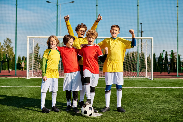 活気あふれるサッカー場の上に活気あふれる若い少年たちの活気あふれるグループが立って,黄金の太陽の下で勝利を明らかにします.. - 写真・画像
