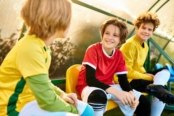 Un groupe de jeunes garçons s'assoient étroitement ensemble, créant un cercle de camaraderie. Ils s'engagent dans la conversation, le rire et des gestes amicaux, mettant en valeur le lien entre amis. - Photo, image