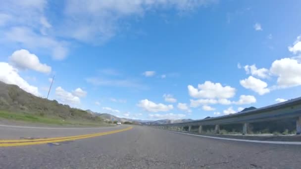 Santa Maria, California, USA-December 6, 2022-Vehicle vaart onder de felle zon over de Cuyama Highway. Het omringende landschap wordt verlicht door de stralende zon, waardoor een - Video