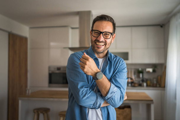 Un homme adulte portrait de caucasien mâle avec barbe et lunettes se tenir à la maison heureux sourire copie espace - Photo, image