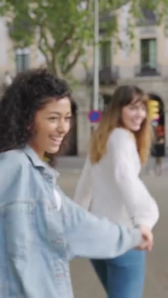 Три счастливые девушки веселятся, бегая вместе по городской улице. Женщины-друзья смеются, наслаждаясь летними каникулами в Барселоне. Молодежь и дружба. - Кадры, видео