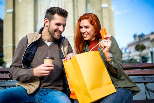 Portret szczęśliwa para z torby na zakupy po zakupy w mieście uśmiechający się i posiadania karty kredytowej - Zdjęcie, obraz