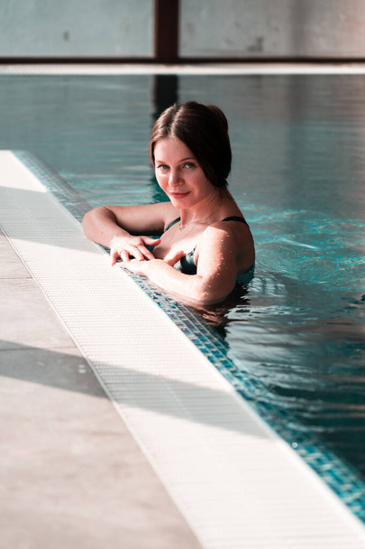 Donna sexy in costume da bagno nuota in piscina.Donna si rilassa nella spa.Relax concetto in hotel - Foto, immagini