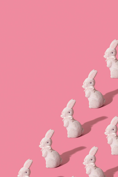 Paskalya için beyaz tavşan deseni sembolü pembe dikey arkaplanda izole edilmiş.. - Fotoğraf, Görsel