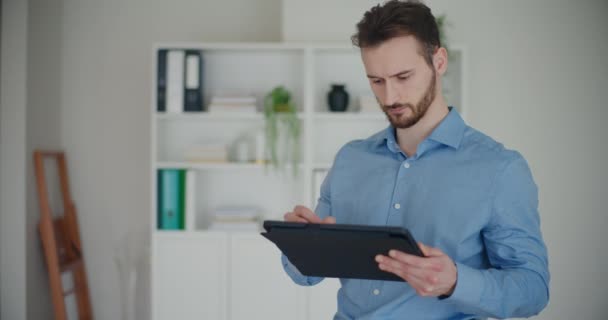 Lockdown πλάνο της αυτοπεποίθηση νεαρός επαγγελματίας χρησιμοποιώντας ψηφιακή tablet με γραφίδα, ενώ στέκεται σε εταιρικό χώρο εργασίας - Πλάνα, βίντεο