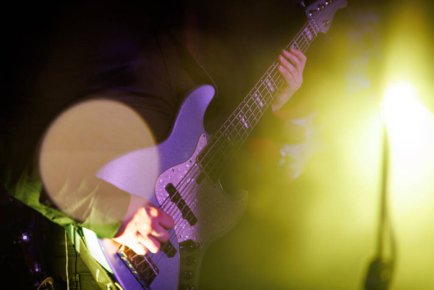 ミュージシャンはロックフェスティバルでステージでベースギターを演奏 - 写真・画像
