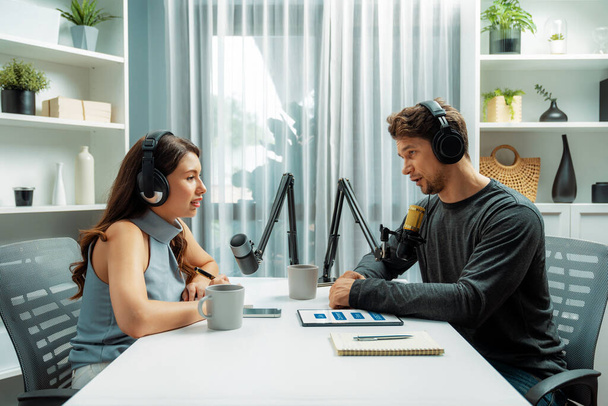 Host channel broadcaster with special guest making advice for problem in live streaming with listeners surrounded sets of live streaming on radio talking show at comfy modern workplace. Postulate. - Photo, Image