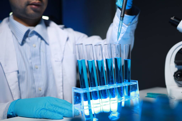 Ein Chemiker testet eine neu entdeckte Chemikalie mit verschiedenen wissenschaftlichen Geräten in seinem Labor. Die Arbeitsatmosphäre im Labor, während Wissenschaftler forschen. - Foto, Bild