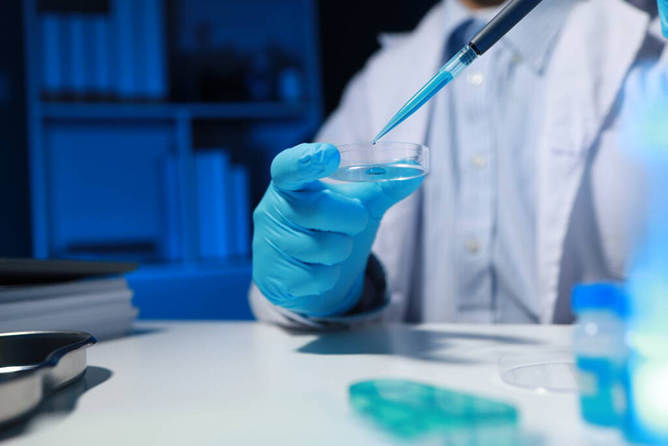 Ein Chemiker testet eine neu entdeckte Chemikalie mit verschiedenen wissenschaftlichen Geräten in seinem Labor. Die Arbeitsatmosphäre im Labor, während Wissenschaftler forschen. - Foto, Bild