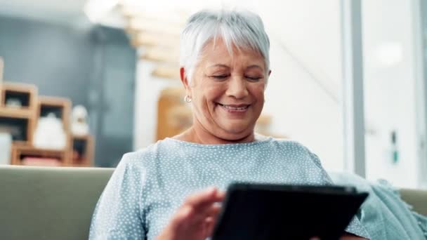 Tablet, kanapé és időskorú nő online, közösségi média és játék mosollyal és boldog szünetben. Nyugdíjba vonulás, otthon és streaming honlapon vagy interneten a nappaliban tech és videó nézése. - Felvétel, videó