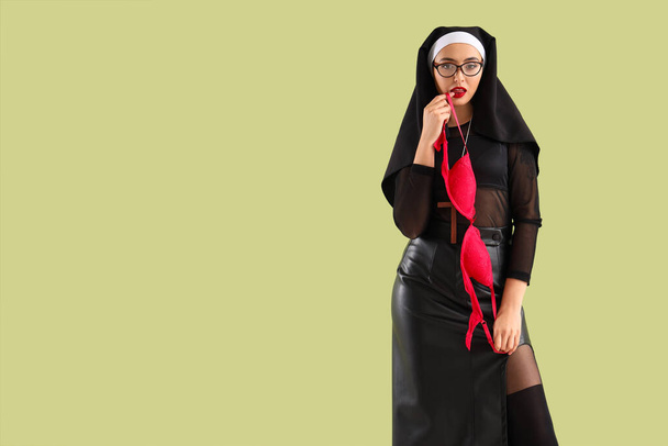 Sexy Nonne in Brille mit BH auf grünem Hintergrund - Foto, Bild
