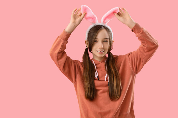 Linda niña con orejas de conejo de Pascua sobre fondo rosa - Foto, imagen