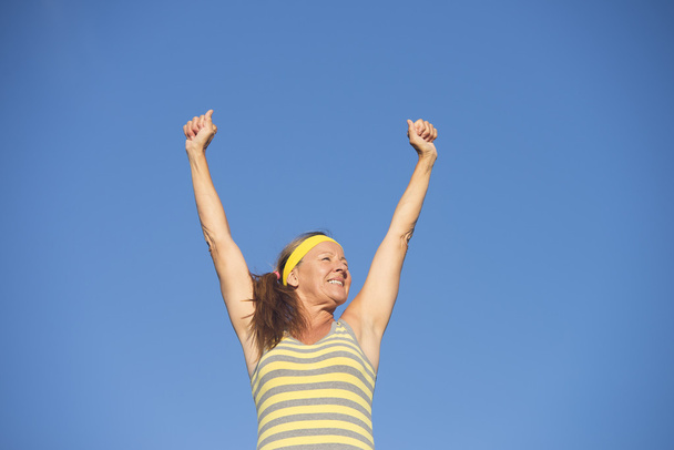 Başarılı uygun sağlıklı kadın kıdemli kollarını kaldır - Fotoğraf, Görsel