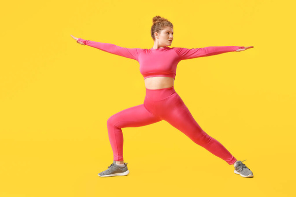 Sporty jeune femme faisant pilates sur fond jaune - Photo, image