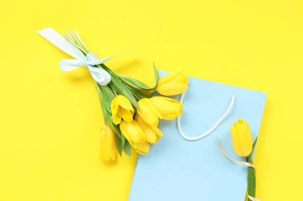 Saco de compras de papel com tulipas no fundo amarelo - Foto, Imagem