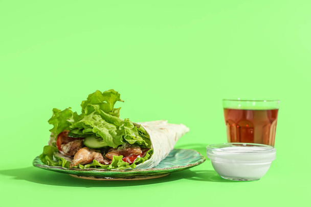 Talíř s chutným doner kebab, omáčka a nápoj na zeleném pozadí - Fotografie, Obrázek