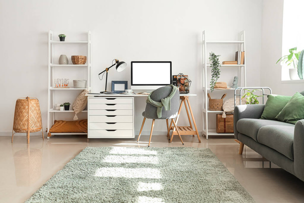 Interiér moderní kanceláře se stylovým pracovištěm, pohovkou a regálovými jednotkami - Fotografie, Obrázek