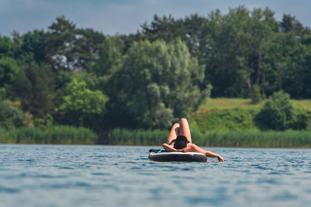 mulher em banho de sol terno de natação no espaço de cópia de bordo - Foto, Imagem