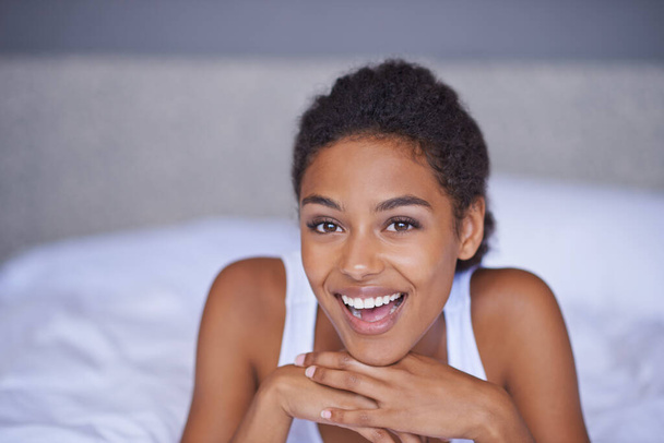 Woman, happy and wellness in bedroom in portrait, peace and confident on morning vacation on home. Young lady, excited face and healthy on break for rest, leisure and enjoy in hotel bed on holiday. - Photo, Image