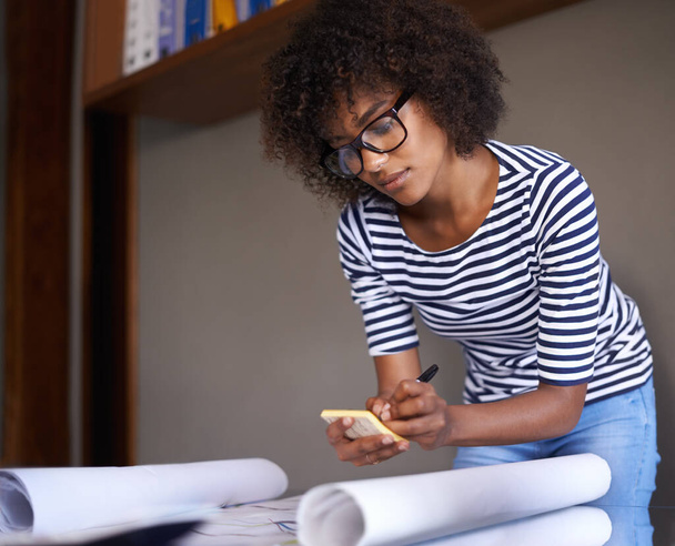 Woman, home and writing on notepad with plans, business and remote work from living room. Strategy, architect and African female person serious and concentrated for architecture by black worker. - Foto, imagen