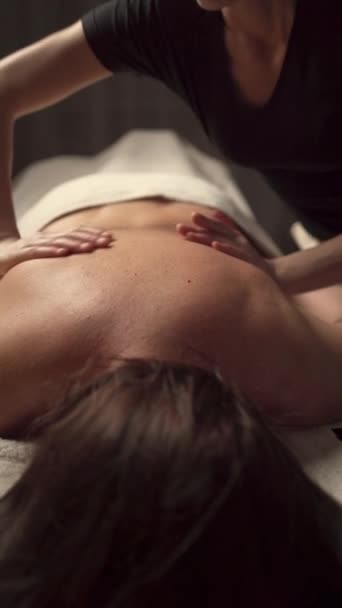 Крупный план массажных рук, делающих массаж спины для женщины в спа-центре. Принято. Концепция эстетического расслабляющего массажа в спа салоне - Кадры, видео