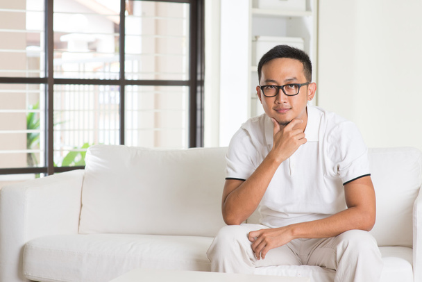 Asian male sitting on sofa - Фото, зображення