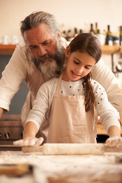 Dziewczyna, dziecko i dziadek do gotowania z ciasta do pieczenia i nauczania ze wsparciem, pomaga lub wałek pin. Rodzina, starszy mężczyzna lub wnuk przygotowujący ciasto w domu do nawiązania więzi lub nauki. - Zdjęcie, obraz
