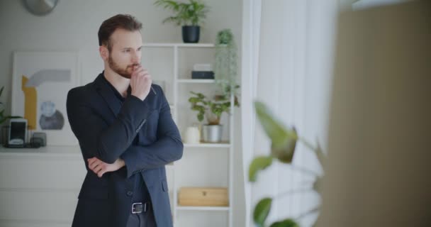 Mladý vousatý podnikatel drží pero brainstorming strategie, zatímco stojí v černém businesswear na firemním pracovišti - Záběry, video