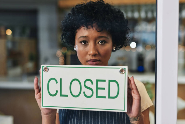 Sad woman, portrait and closed sign on window at cafe in small business, bankruptcy or out of service. Female person or restaurant waitress holding billboard for fail or debt at coffee shop or store. - Photo, Image