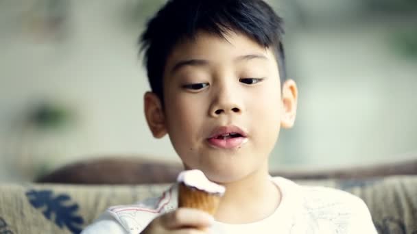 Kis-ázsiai Aranyos fiú élvezni eszik fagylaltot - Felvétel, videó
