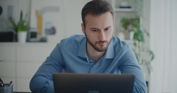 Magabiztos fiatal férfi professzionális böngészés internet használata közben laptop vállalati munkahelyen - Felvétel, videó