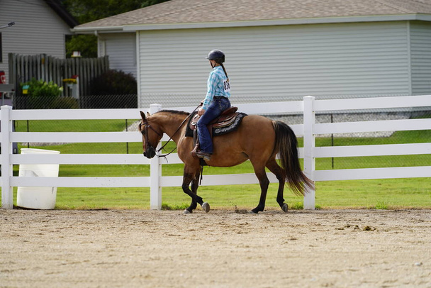 Fond du Lac, Wisconsin / USA - 17 lipca 2019: Młoda dziewczyna jeżdżąca na koniu na publicznym ranczu w Fond du Lac, Wisconsin - Zdjęcie, obraz