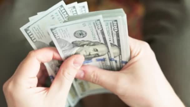 Mains caucasiennes comptant une pile de billets de cent dollars américains, gros plan avec mise au point sélective et ralenti - Séquence, vidéo