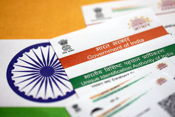 Carta Aadhaar indiana della Unique Identification Authority of India sulla bandiera indiana da vicino - Foto, immagini